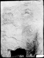 Верхняя часть входа в склеп с высеченным над ним в скале человеческими головами грубой работы