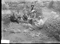 Sitting figures of three workers, excavations head G. D. Belov, and excavation architect S. F. Strzheletskiy